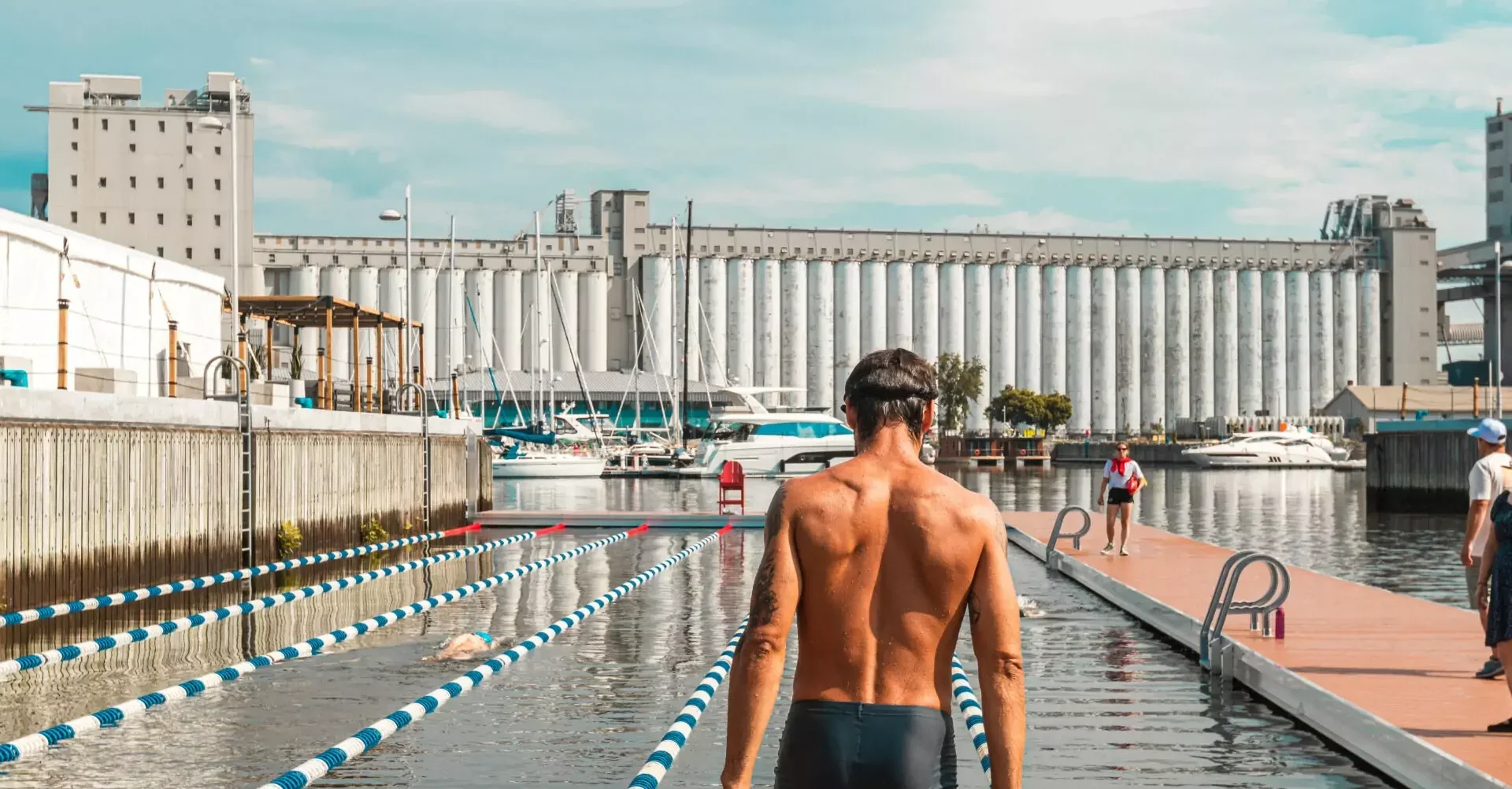 A swimmer getting ready to dive into a pool divided by swim lanes