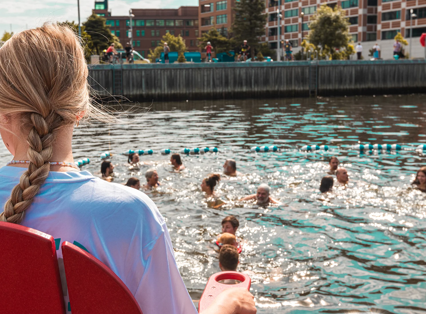 Sauveteuse vue de dos surveillant plusieurs baigneurs